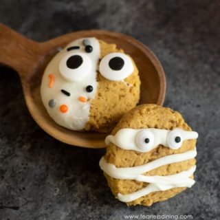 two Halloween decorated pumpkin cookies