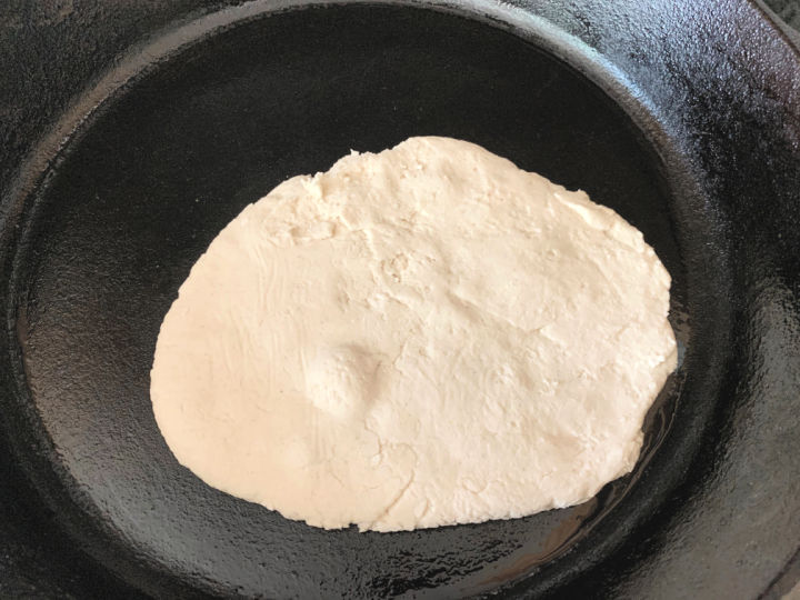 Flatbread cooking in a cast iron skillet.