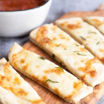 A cutting board with cut gluten free flatbread.