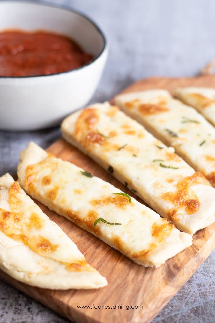 A cutting board with cut gluten free flatbread.