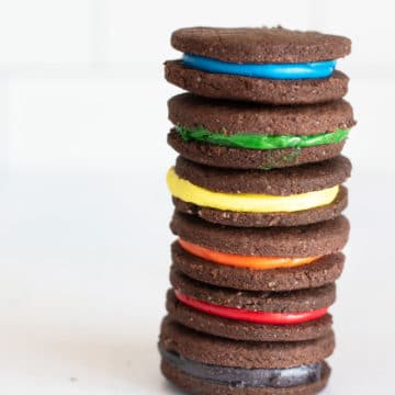 A tall stack of gluten free rainbow oreo cookies.