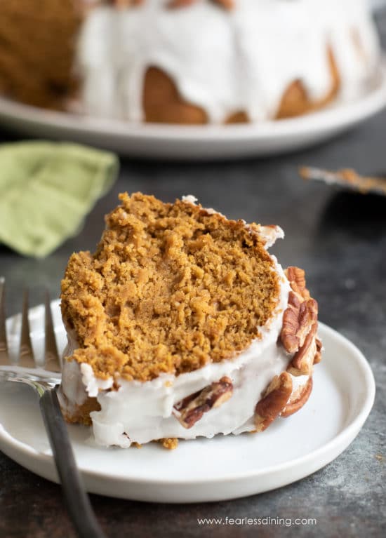A slice of gluten free pumpkin bundt cake on a plate with a fork.