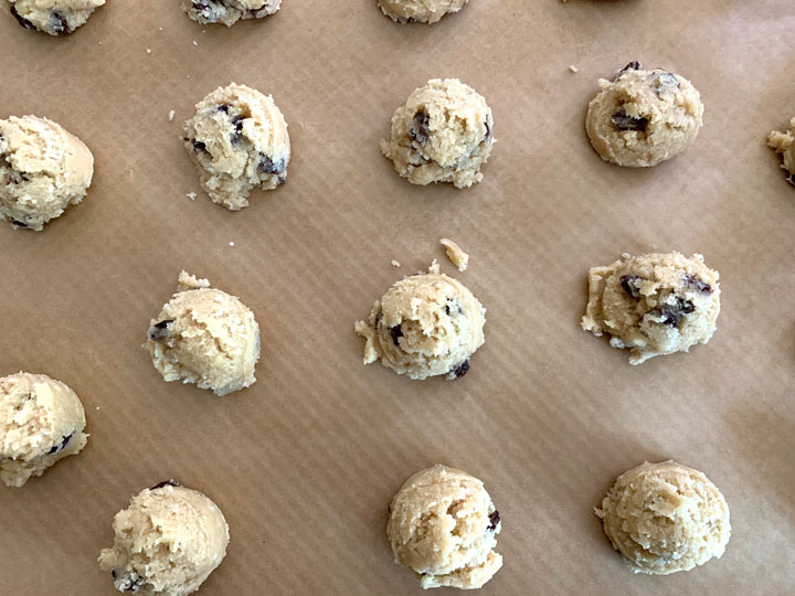 Rum raisin cookie dough balls on a baking sheet.