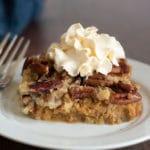 A slice of gluten free pumpkin dump cake with pumpkin spice whipped cream.