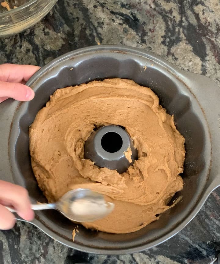 Spreading the batter in a bundt pan.