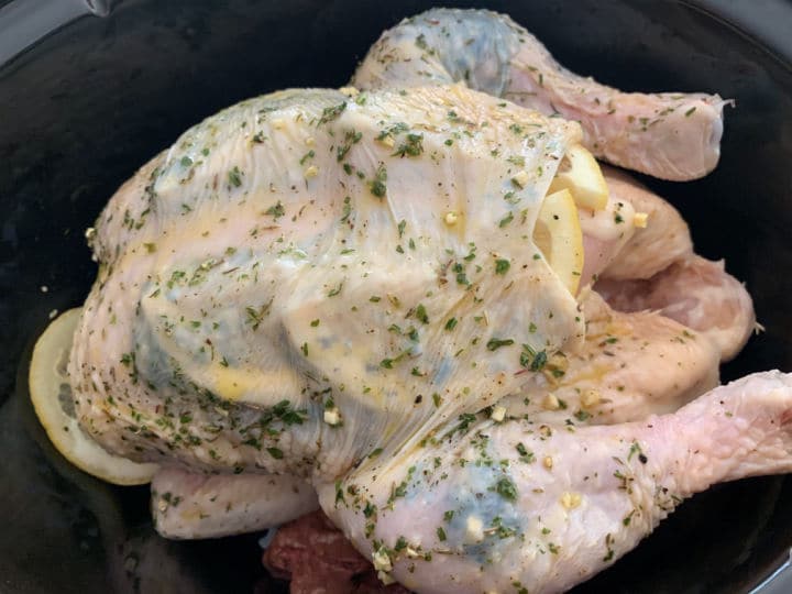 a raw chicken with seasoning stuffed under the skin