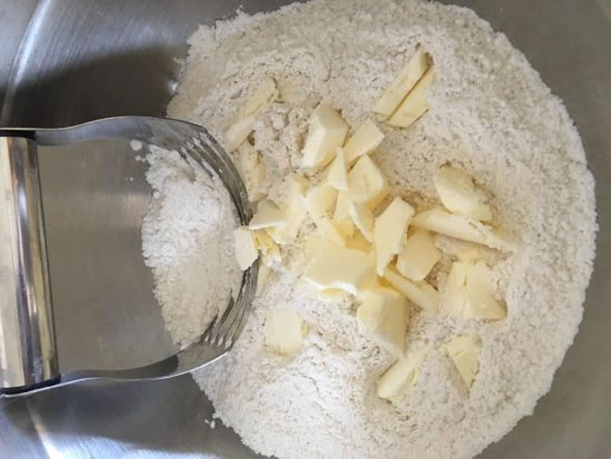 a bowl of gluten free flour and cold butter chunks