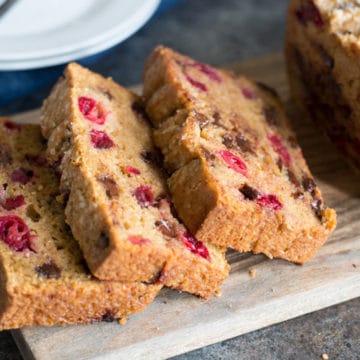 A sliced cranberry chocolate chip loaf on a cutting board.