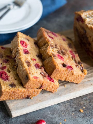 A sliced cranberry chocolate chip loaf on a cutting board