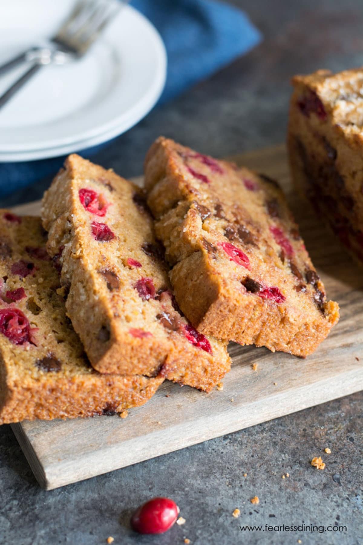 A sliced cranberry chocolate chip loaf on a cutting board.