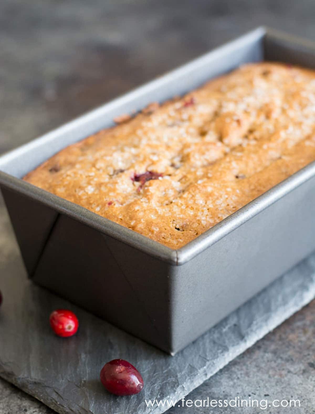 A baked cranberry bread in a loaf tin.