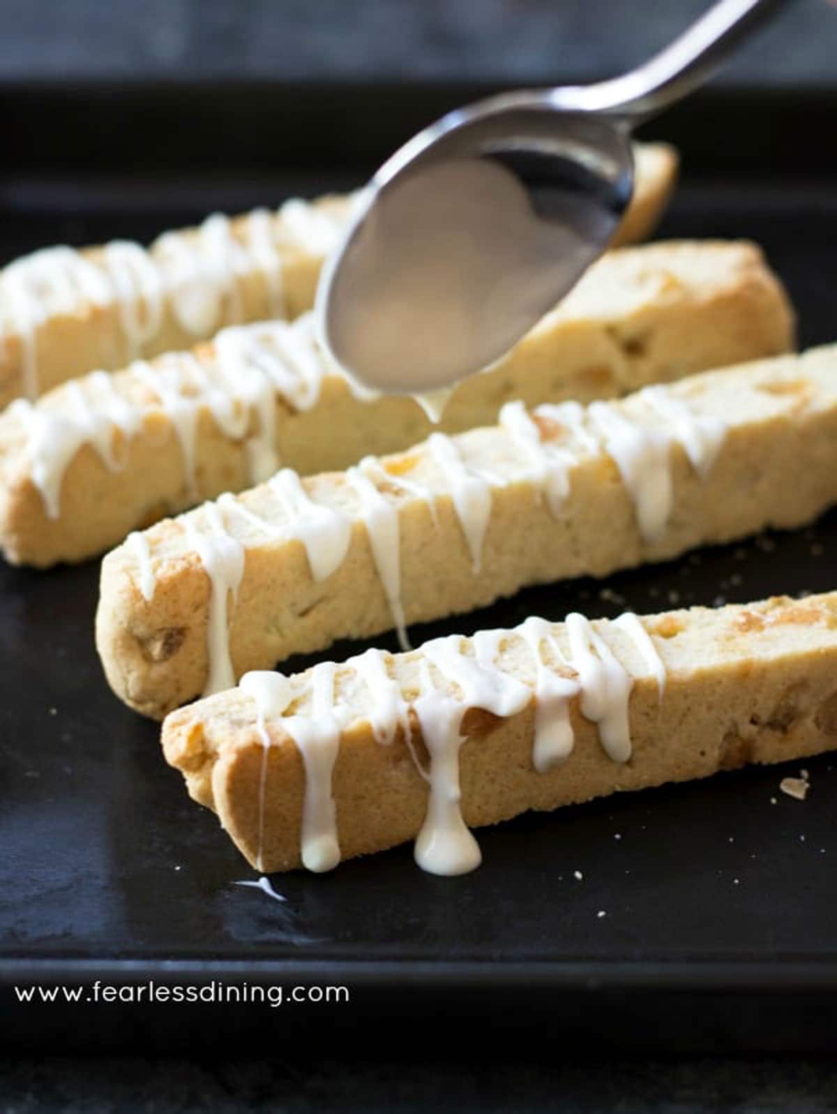 drizzling white chocolate over the biscotti