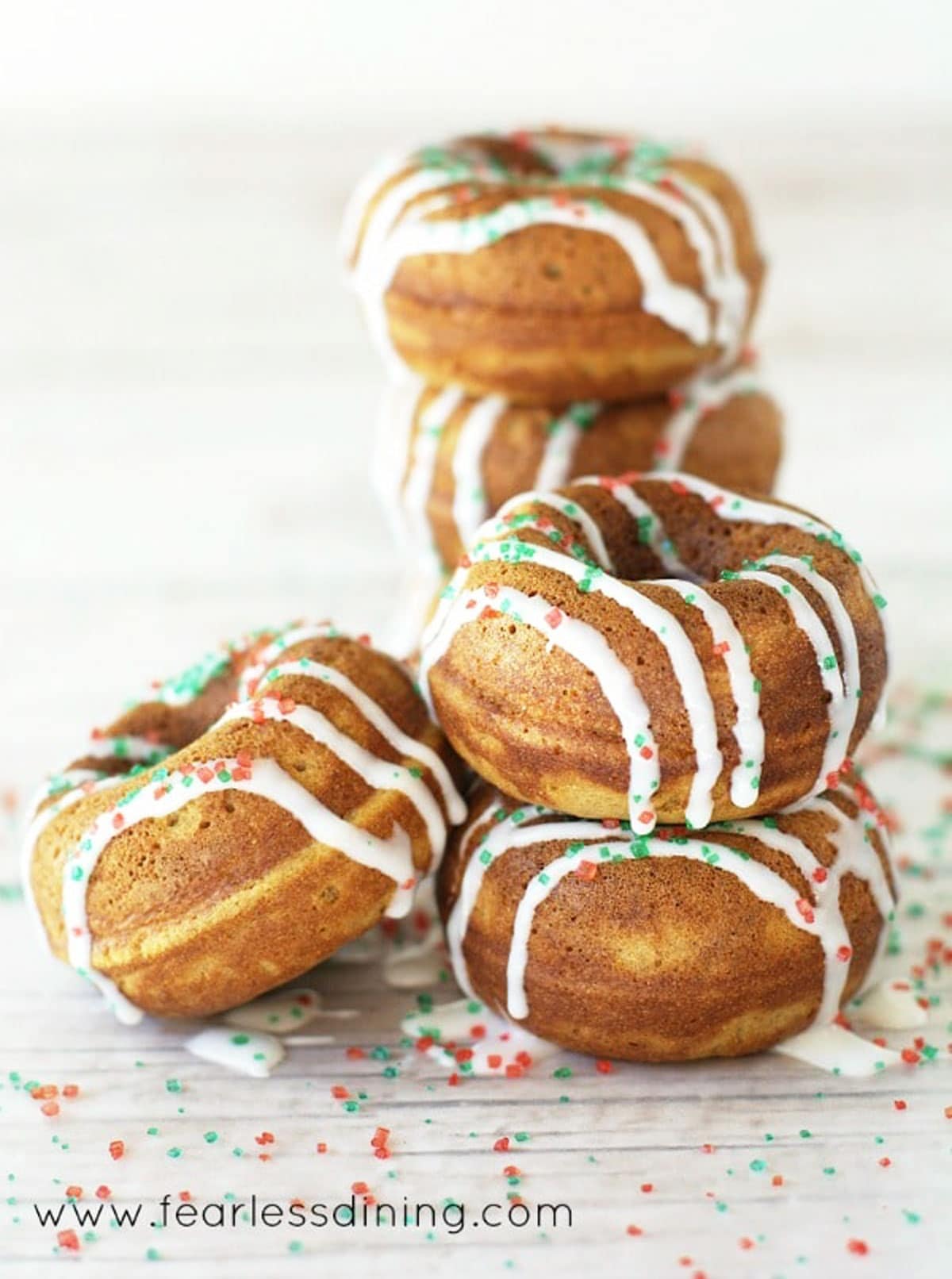 A big stack of gingerbread donuts on a counter.