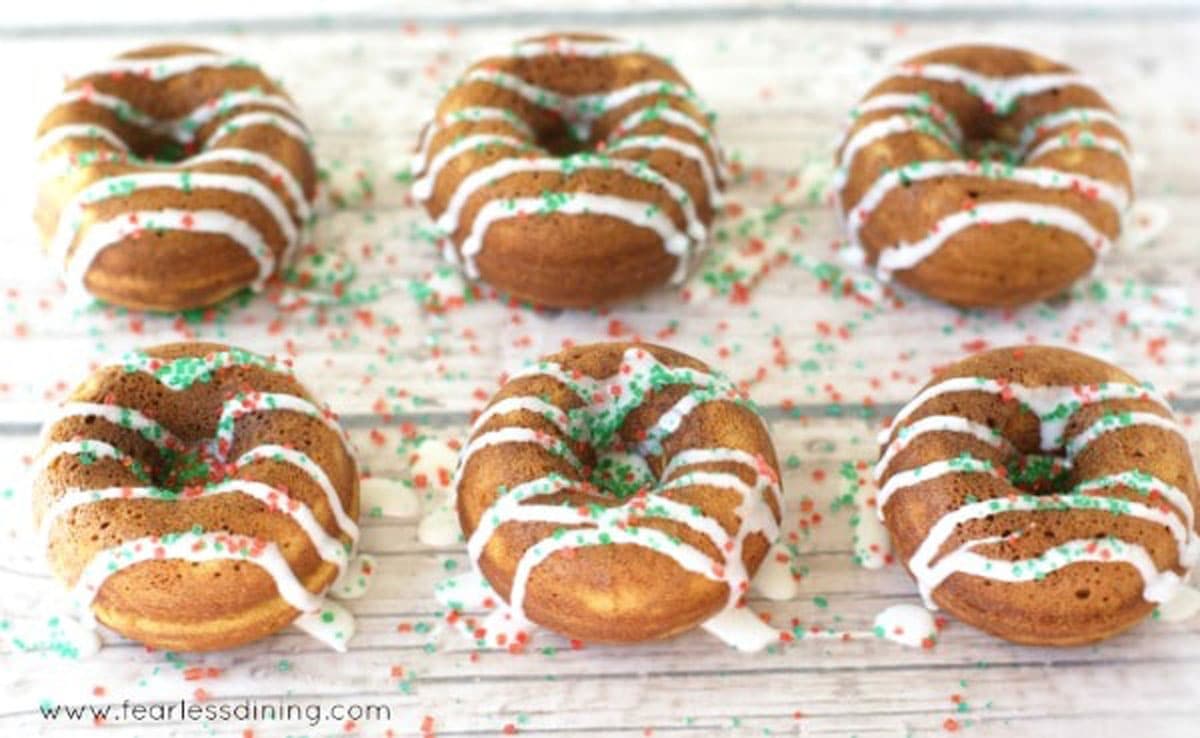 Two rows of gingerbread donuts on a rack.