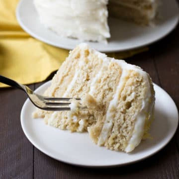 A fork slicing into a piece of lemon cake.