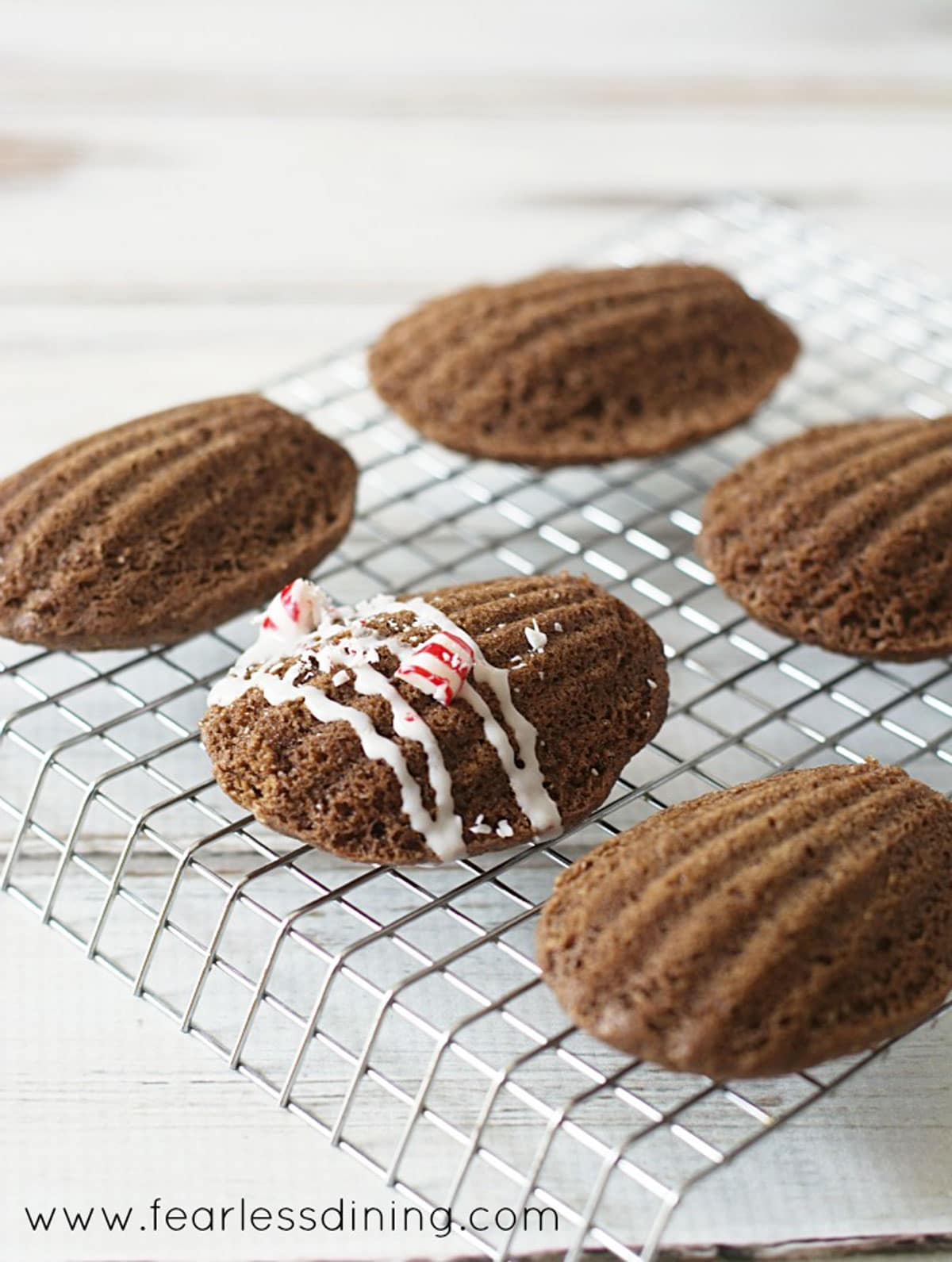 Madeleines on a cooling rack being decorated.