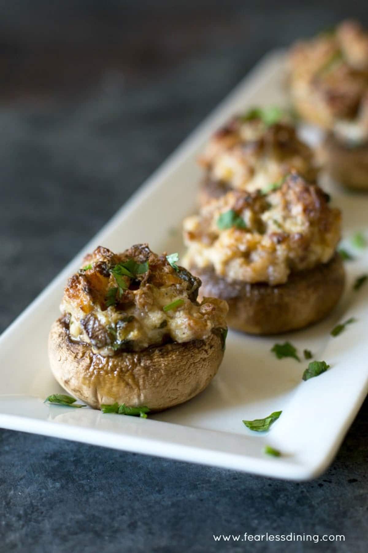 A serving dish with stuffed mushrooms lined up.