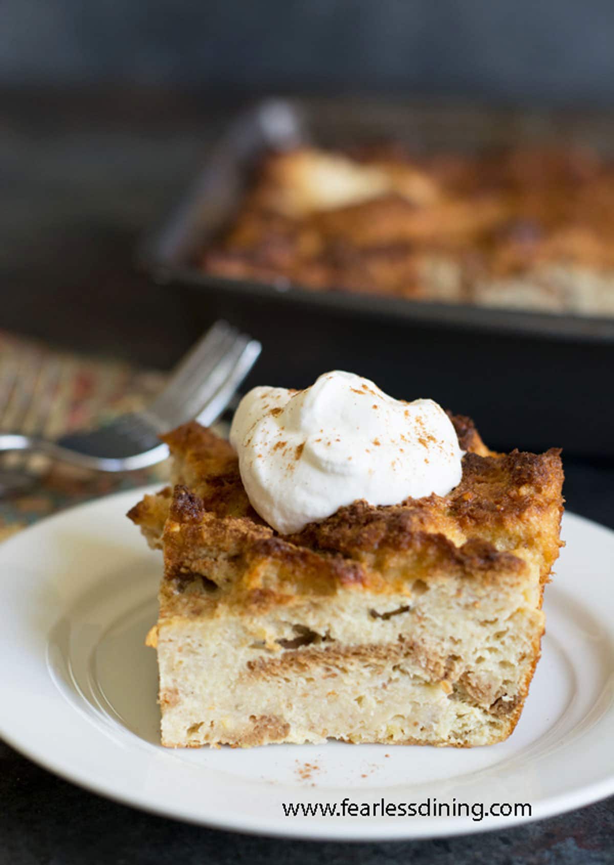 A slice of eggnog bread pudding on a plate.