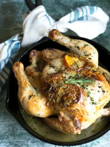 a whole roasted chicken in a cast iron skillet