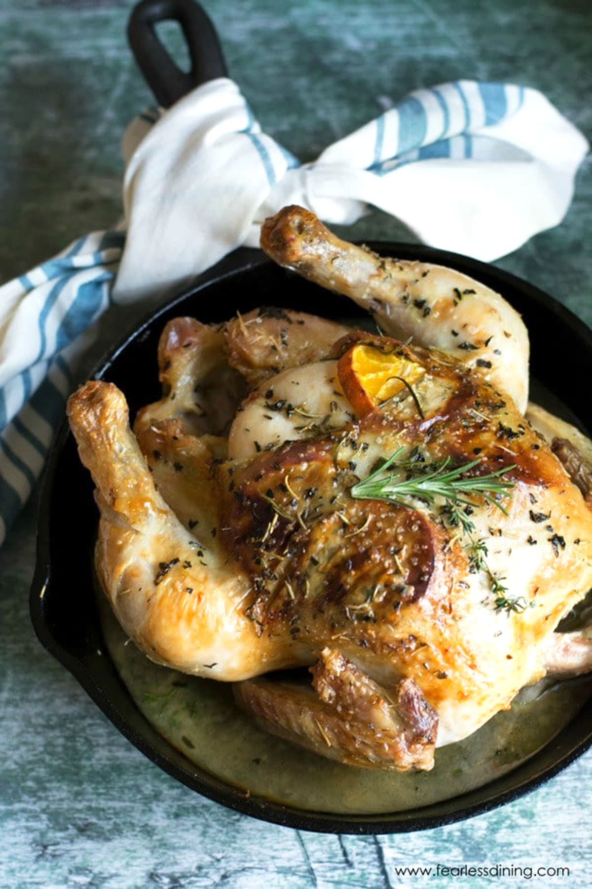 A whole roasted chicken in a cast iron skillet.