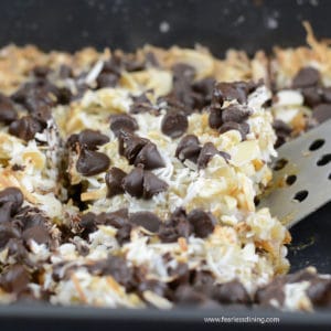 scooping out a slice of gingerbread 7 layer bars