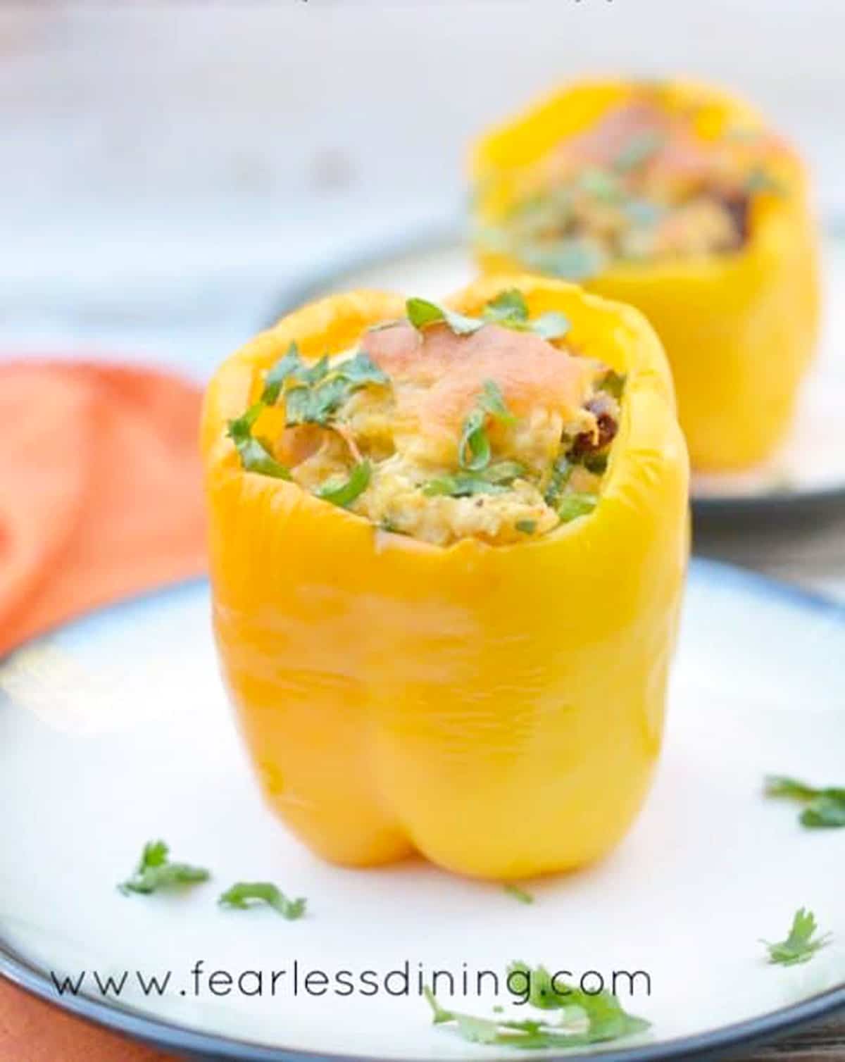 Big stuffed yellow peppers on two plates.