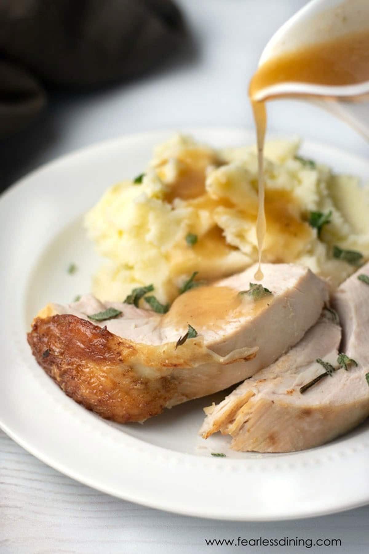 Pouring gravy on sliced turkey breast.