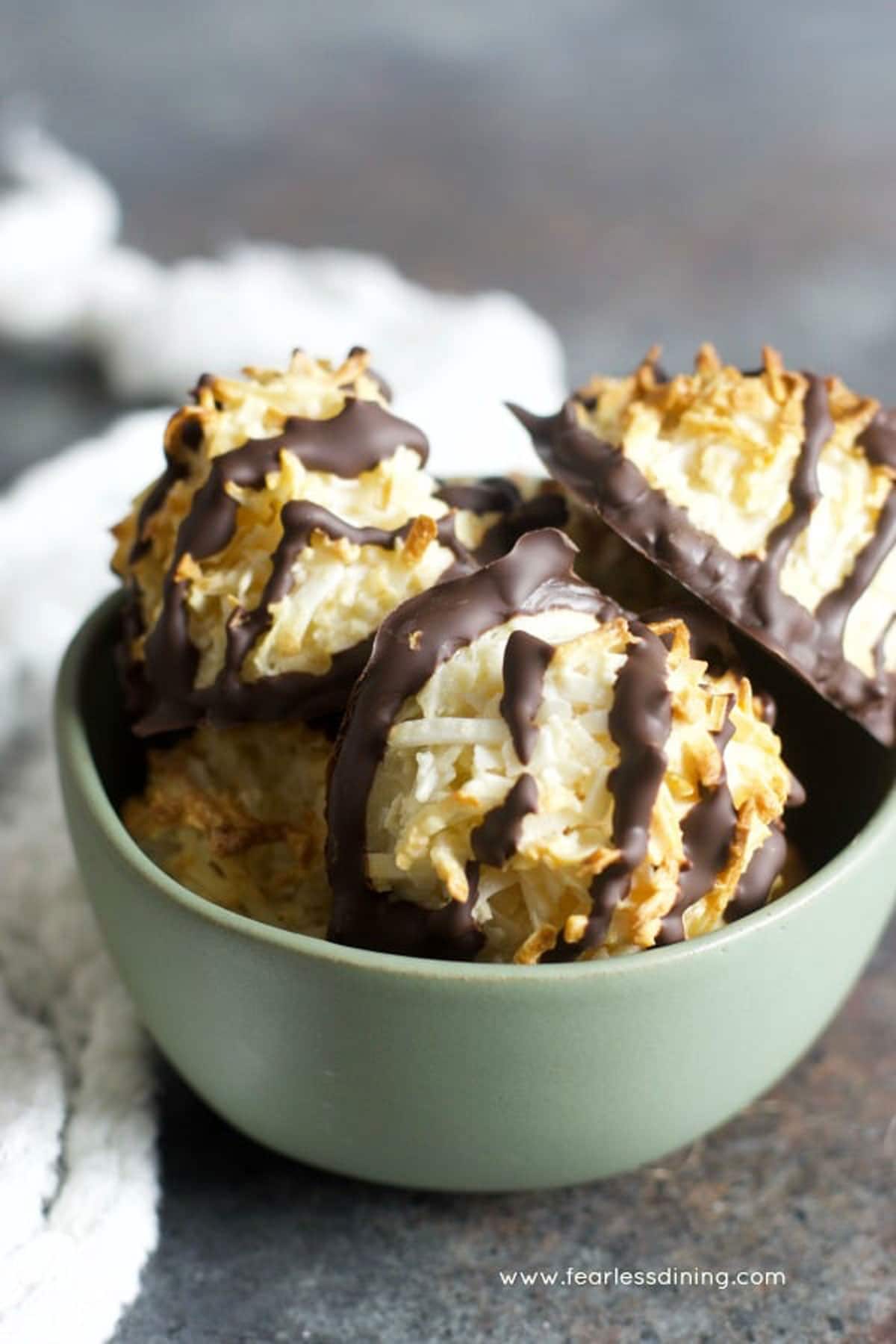 A bowl of chocolate dipped coconut macaroons.