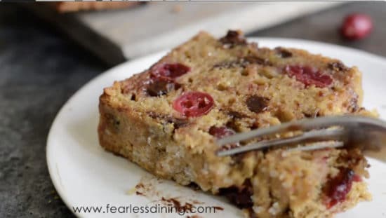 A fork cutting into a slice of cranberry bread.