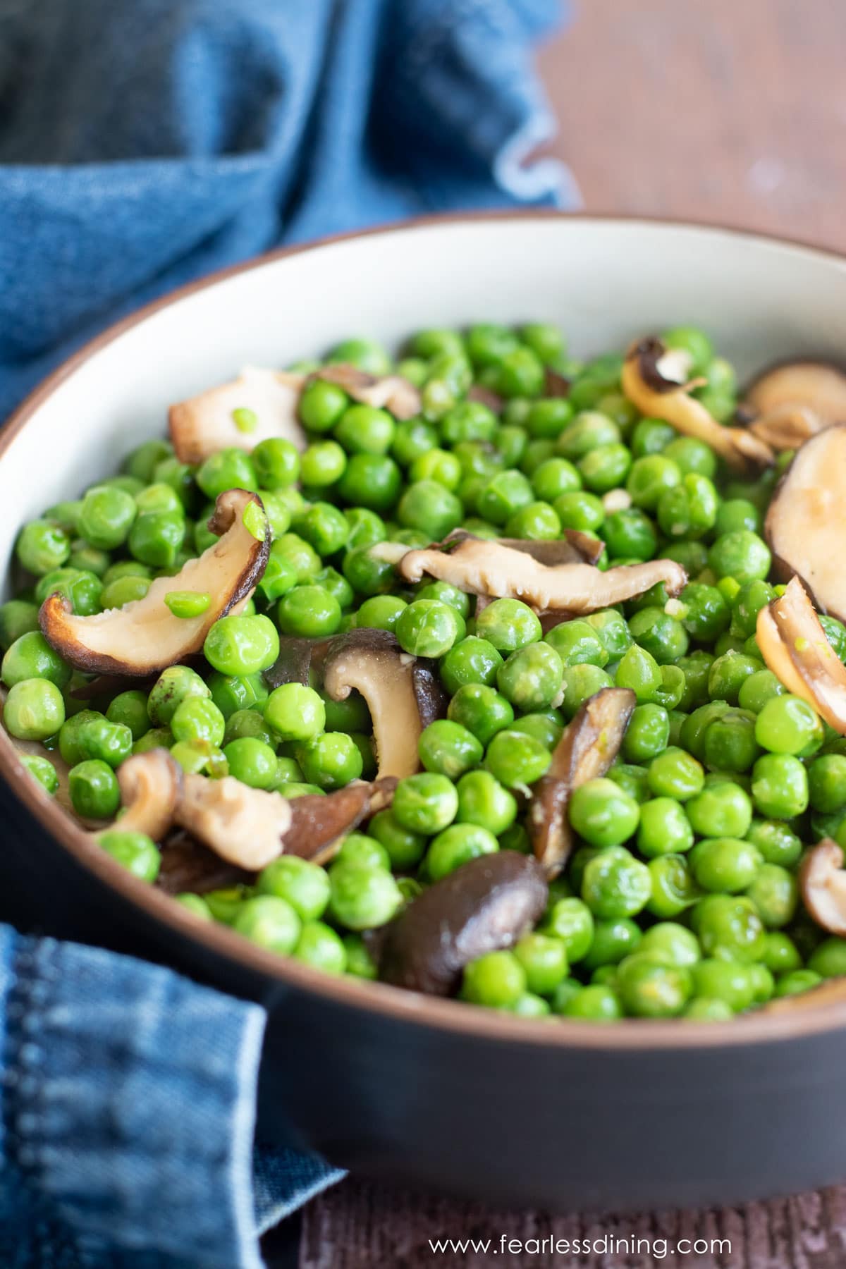A close up of a bowl of ginger peas with shiitake mushrooms.
