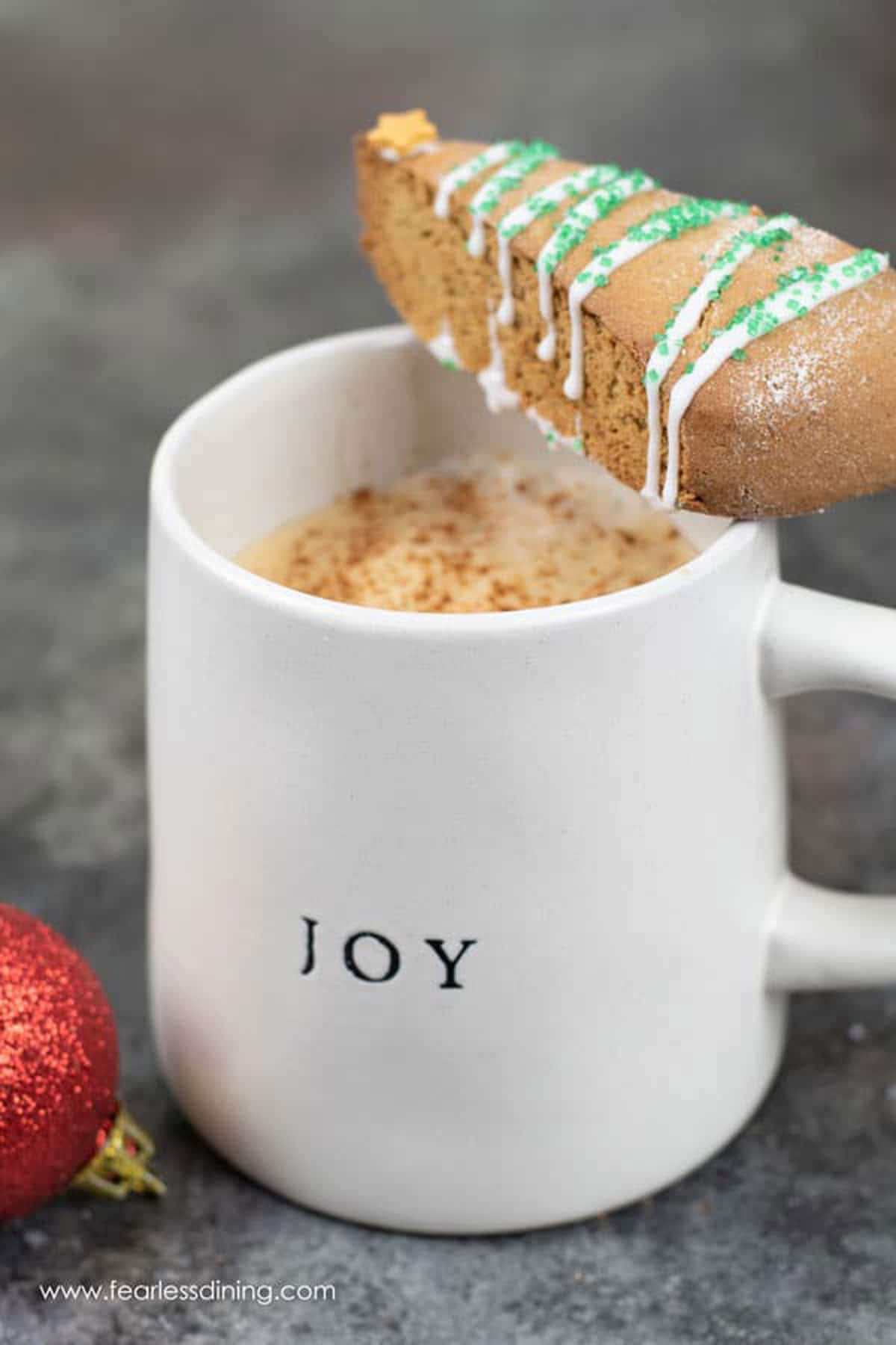 A slice of biscotti on a coffee mug.