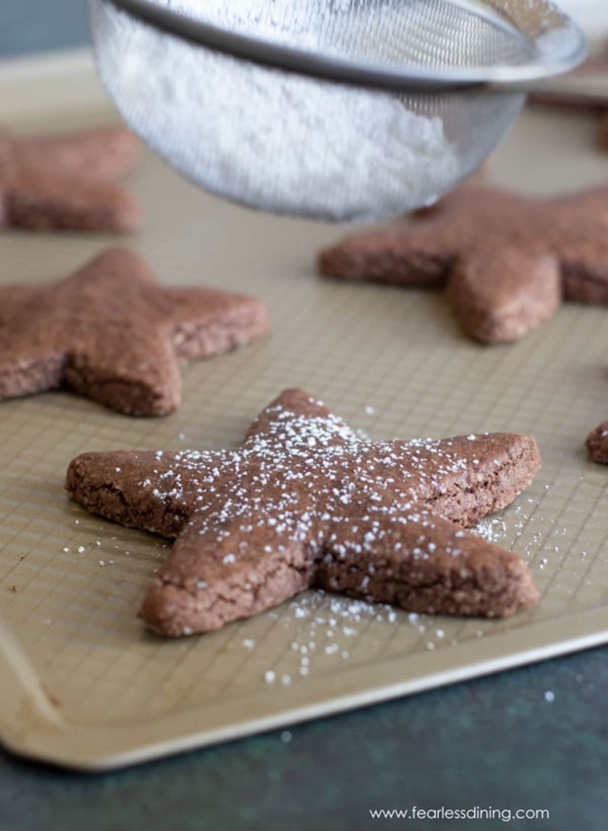 Dusting cookies with powdered sugar.