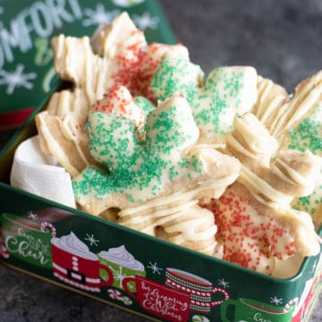 A metal holiday gift tin filled with gluten free cardamom cookies.