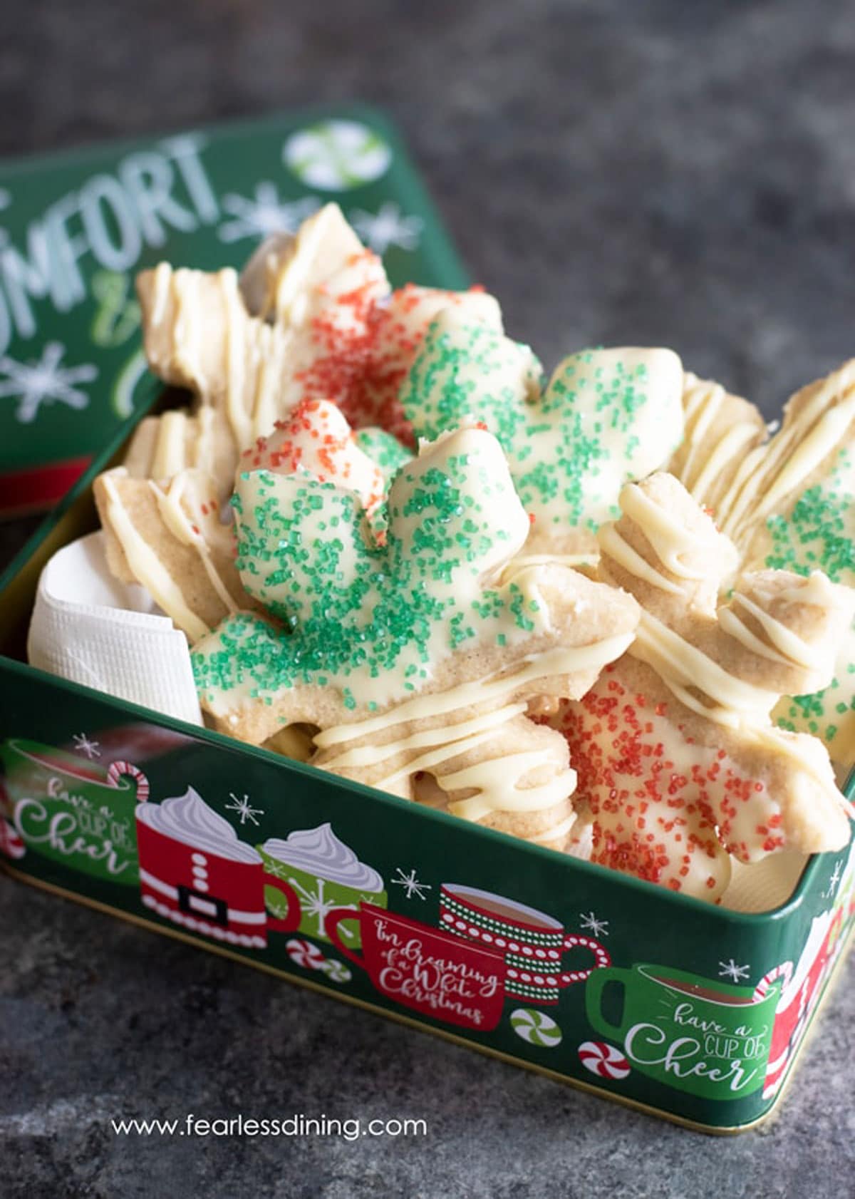 A metal holiday gift tin filled with cookies.