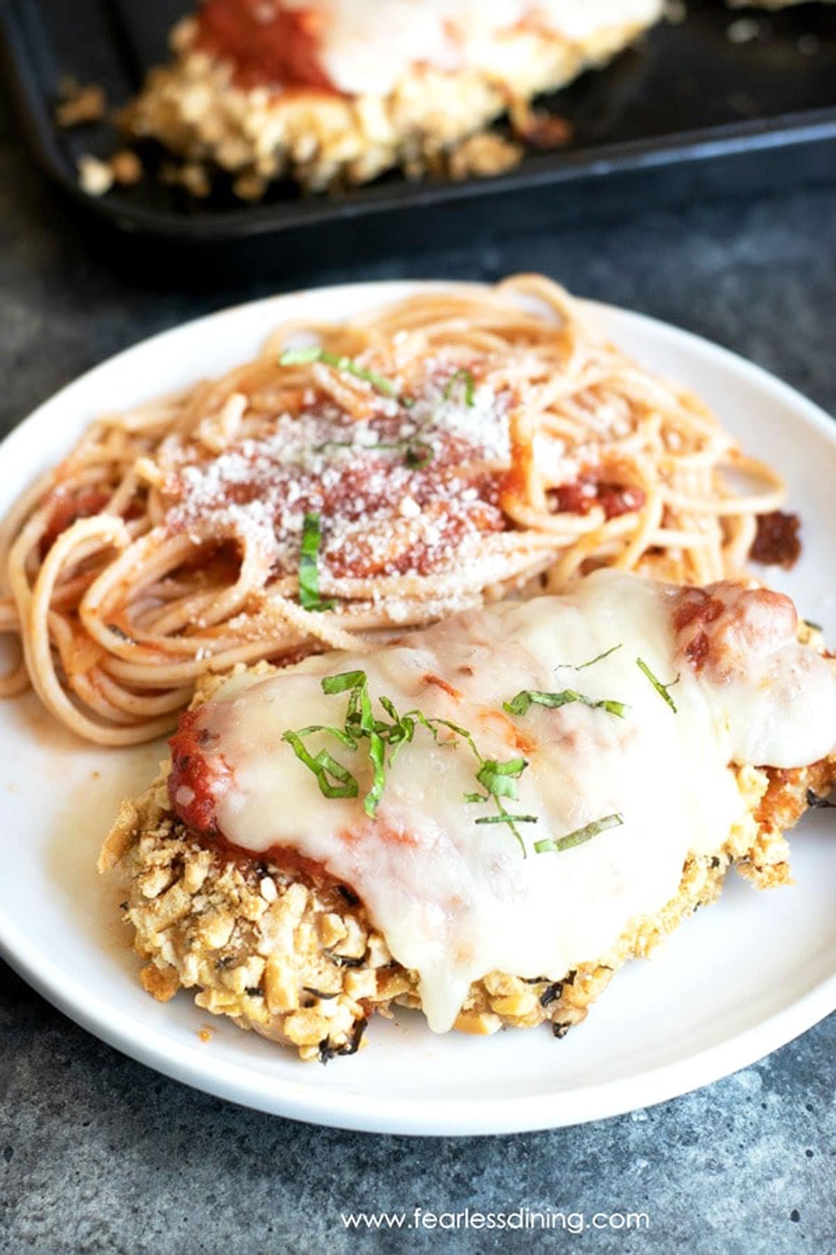 a plate with chicken parmesan and spaghetti