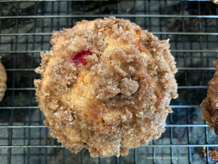 A close up of a baked cranberry streusel muffin.
