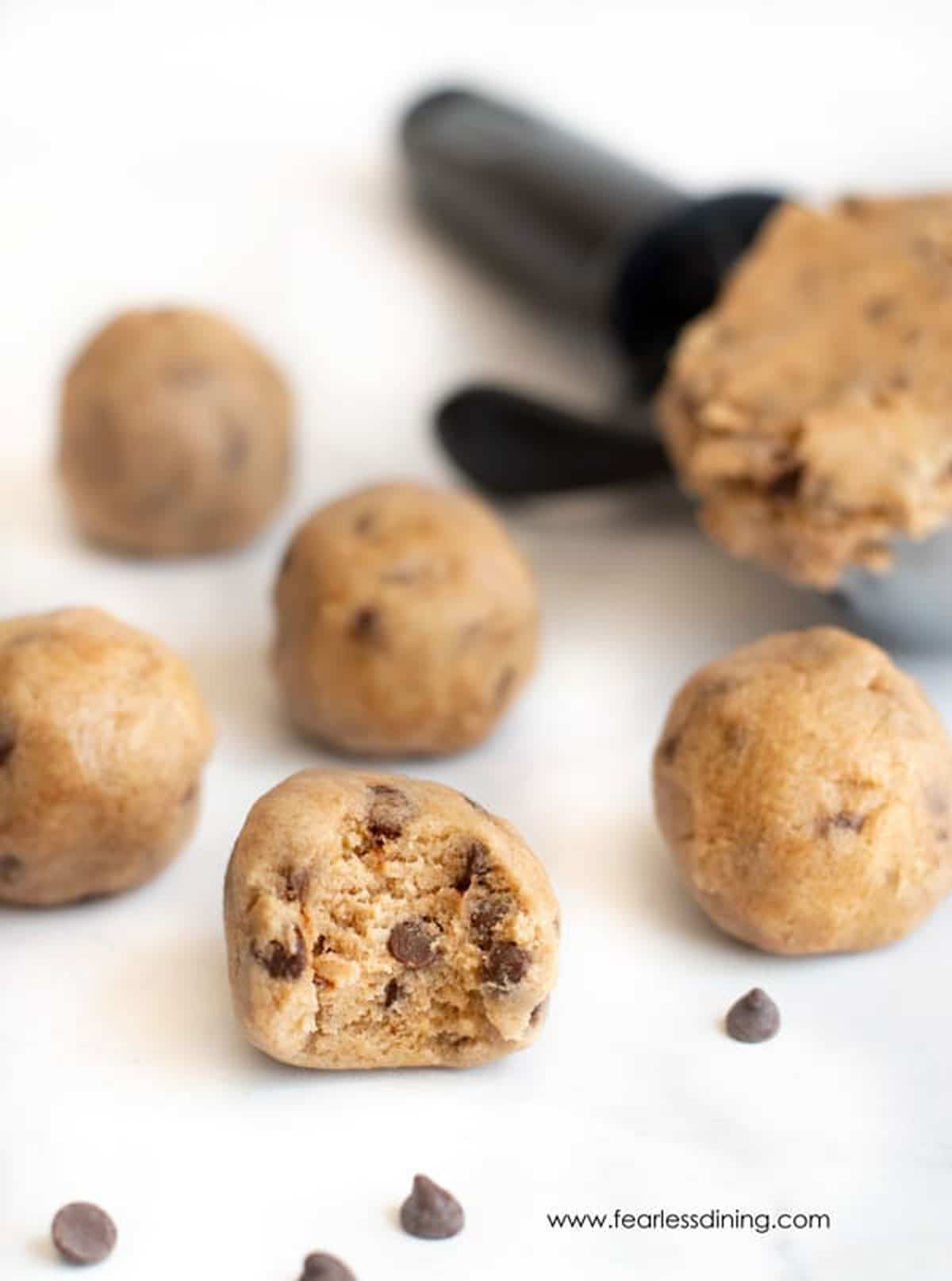Several cookie dough balls on the counter.