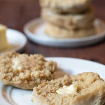 a close up of an English muffin on a plate with butter