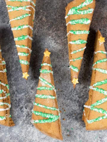 gingerbread biscotti decorated like Christmas trees on a pan