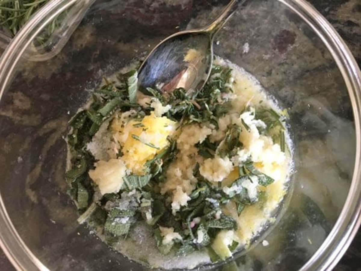 A bowl with fresh herbs butter and fresh chopped herbs.