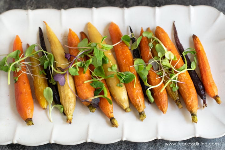 a horizontal picture of a platter of maple carrots