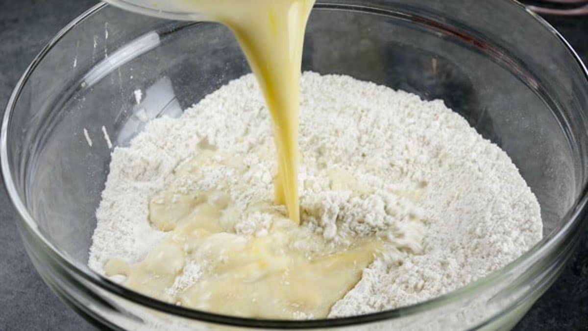 Pouring the wet ingredients into the dry ingredients.