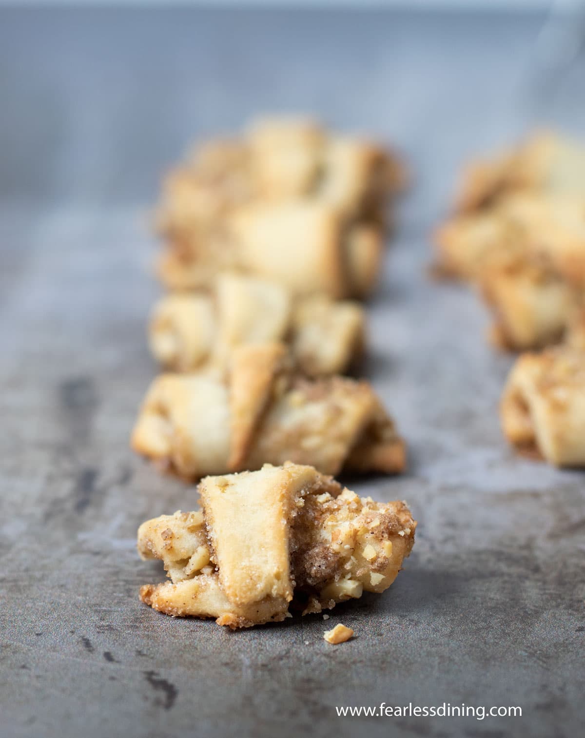 A close up of baked gluten free rugelach on a cookie sheet.