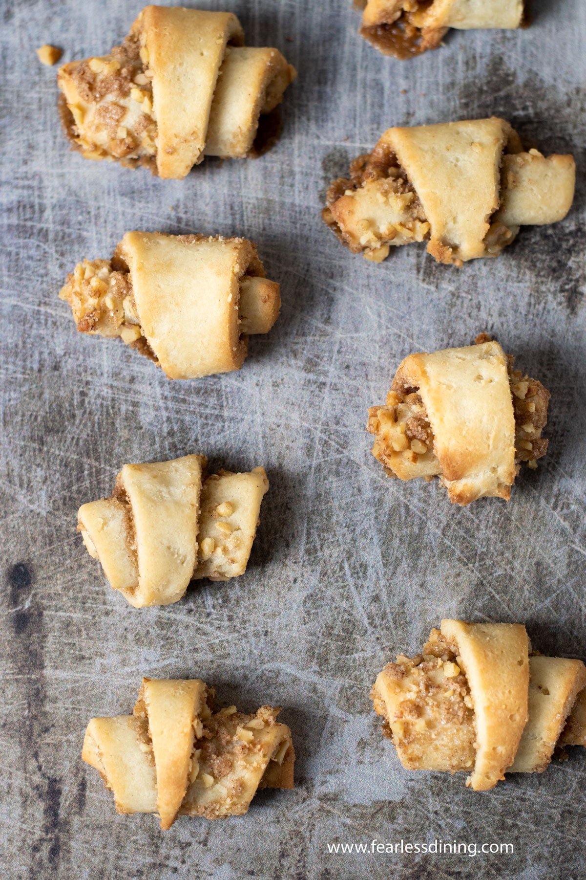 Baked rugelach on a cookie sheet.