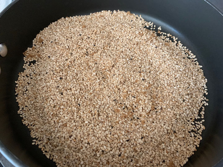 Toasting sesame seeds in a pan.