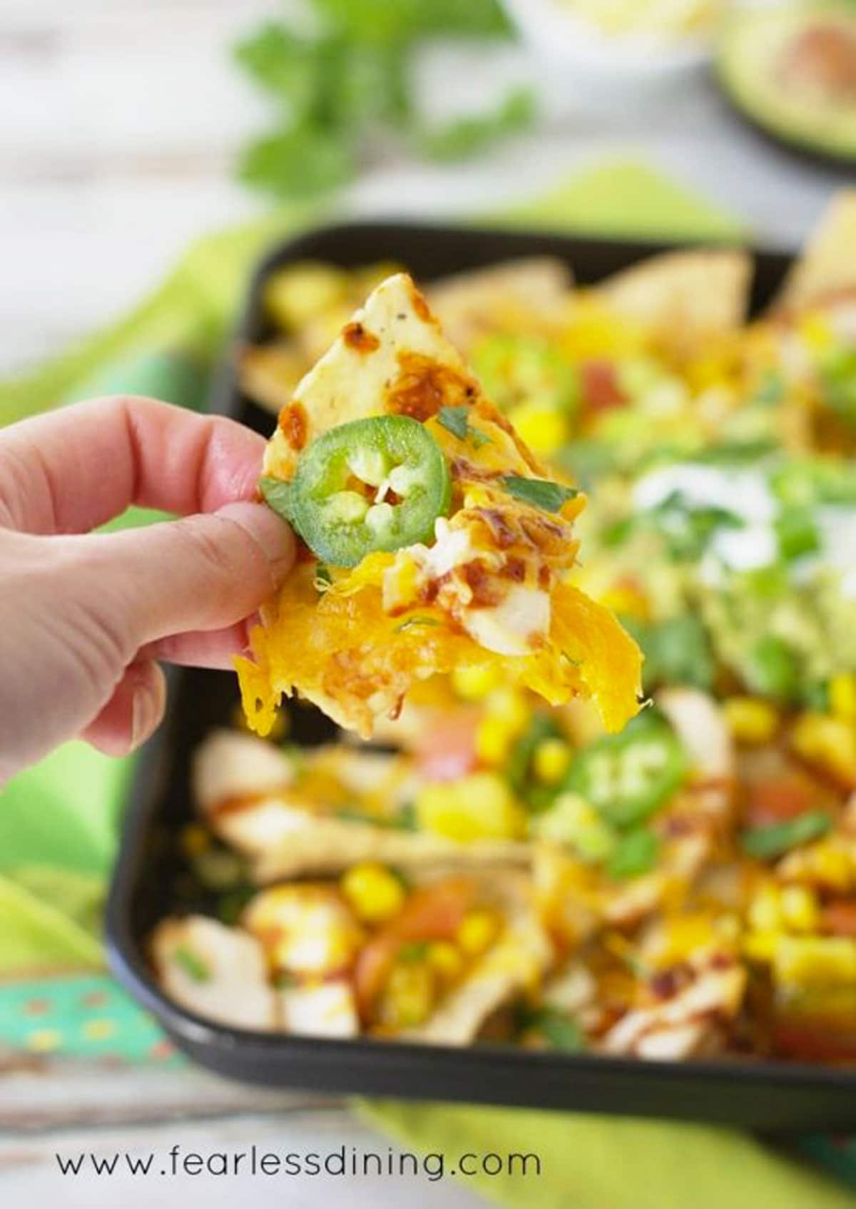 Holding up a barbecue chicken nacho.