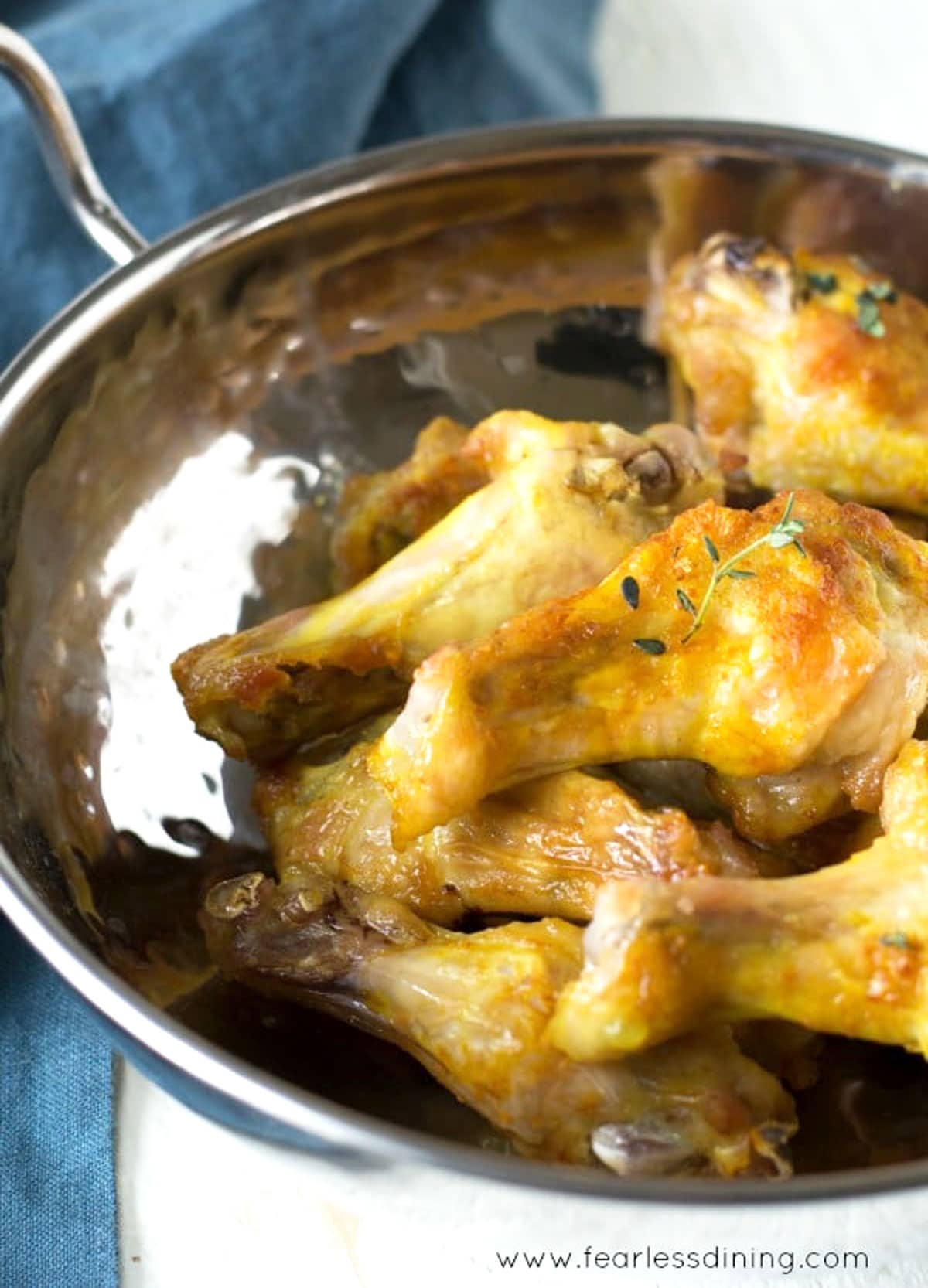 A big silver serving dish full of the air fried chicken wings in a bowl