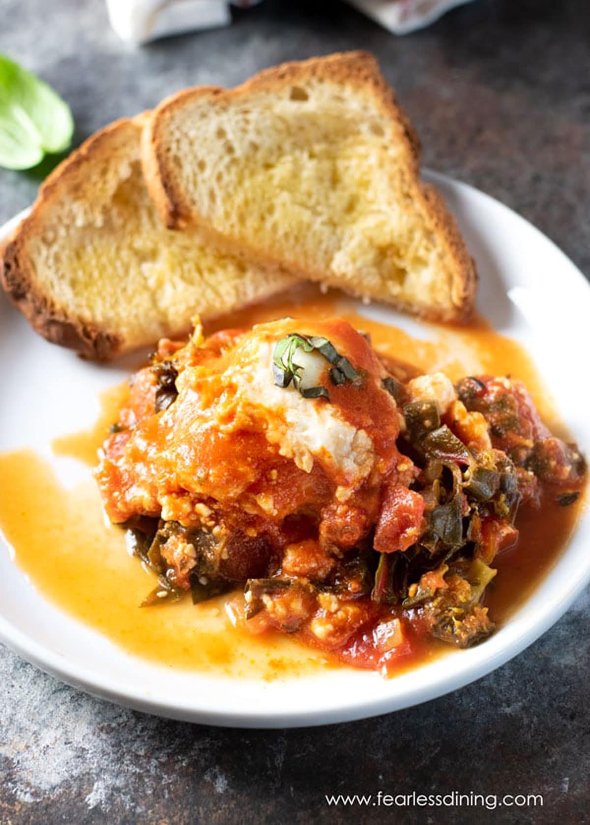 A plate filled with shakshuka and toast.