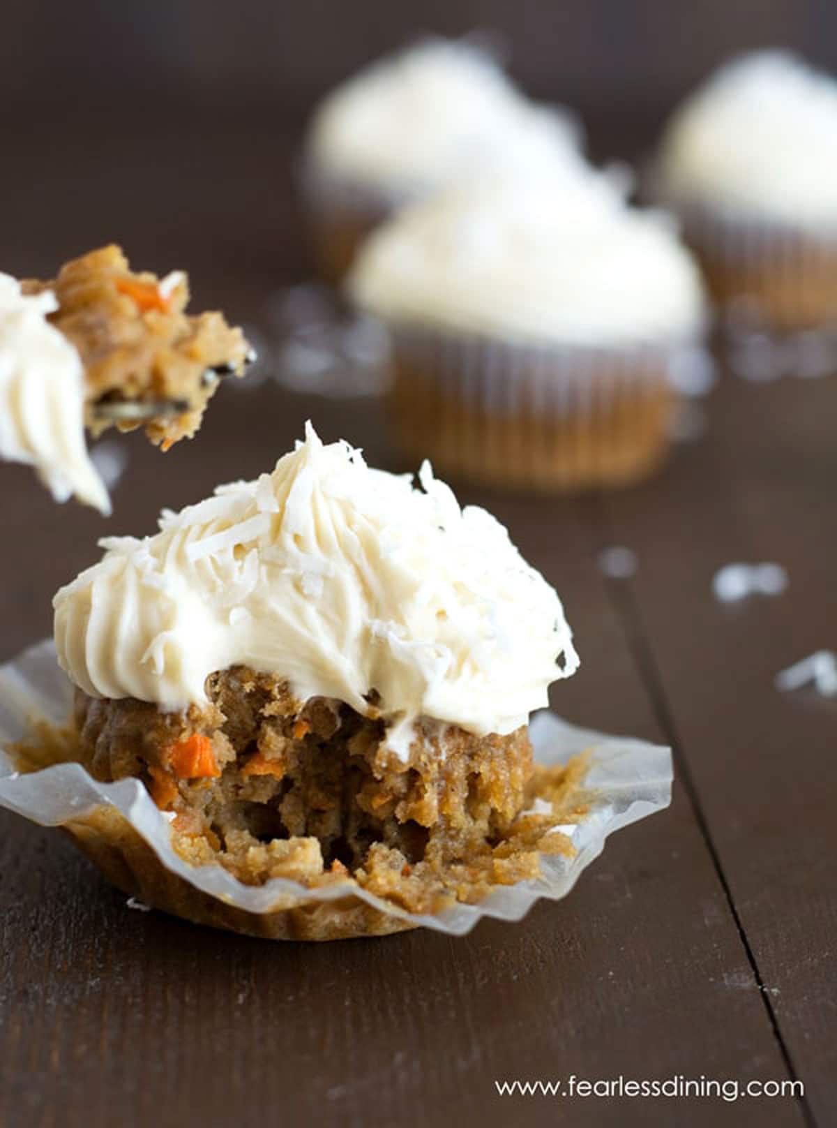A carrot cupcake with a bite taken out.