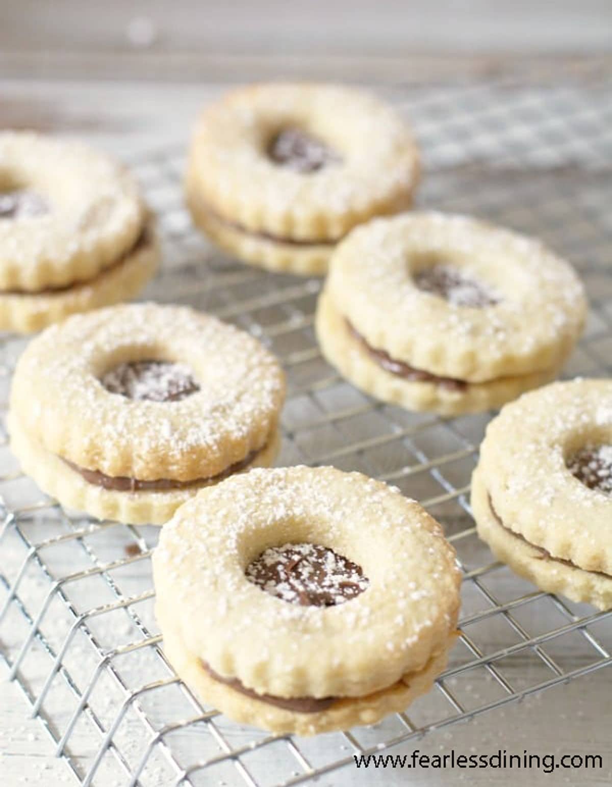 Rows of linzer cookies dusted with powdered sugar.